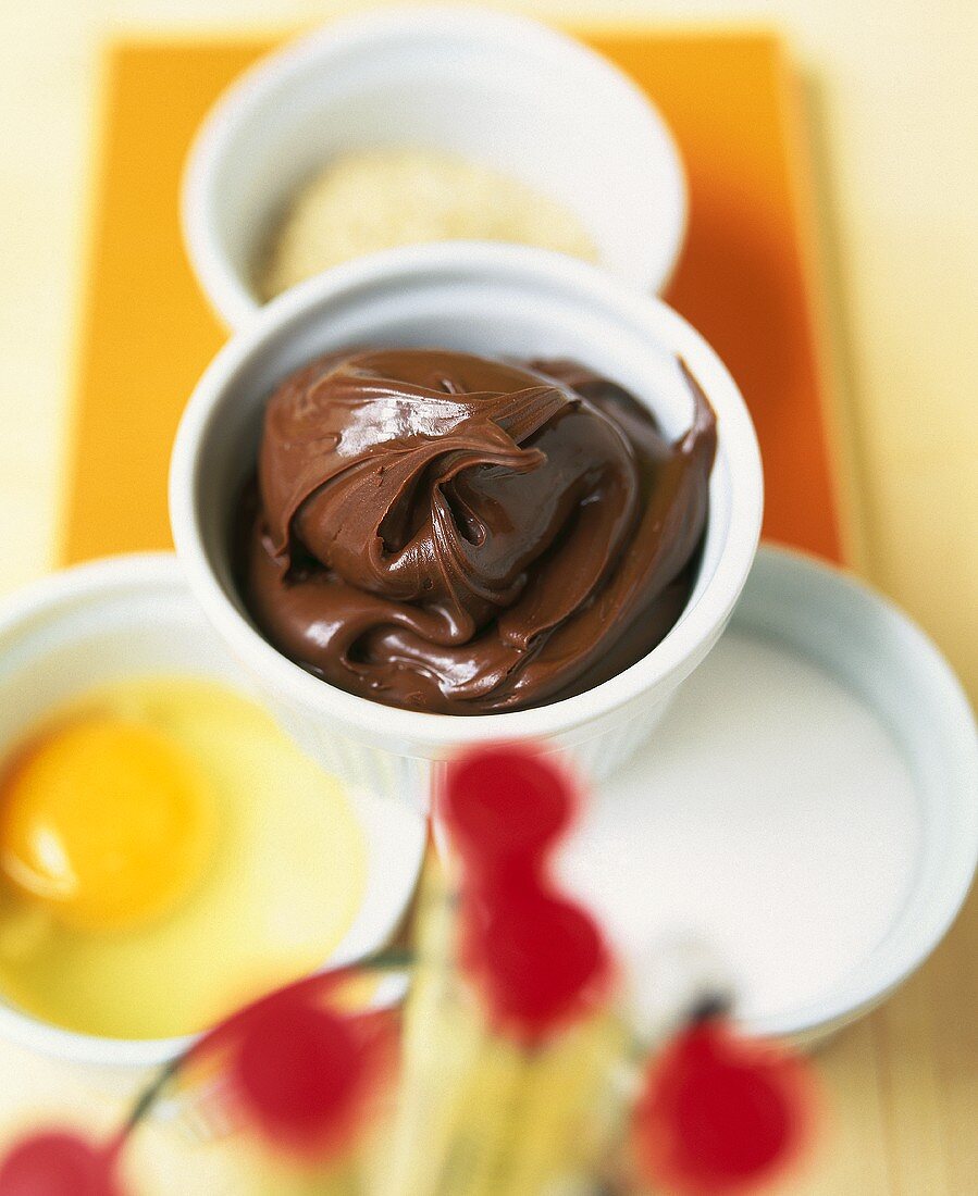 Soufflé dish with chocolate spread and baking ingredients