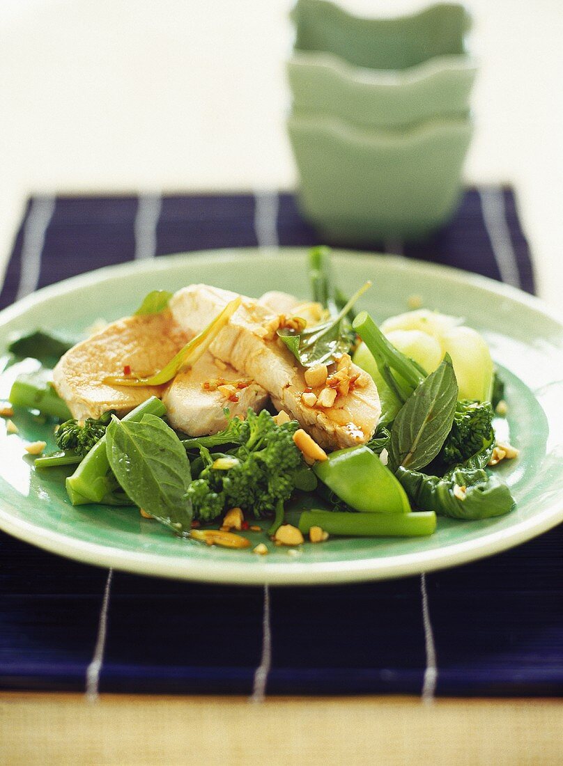 Poached chicken breast on a bed of green vegetables