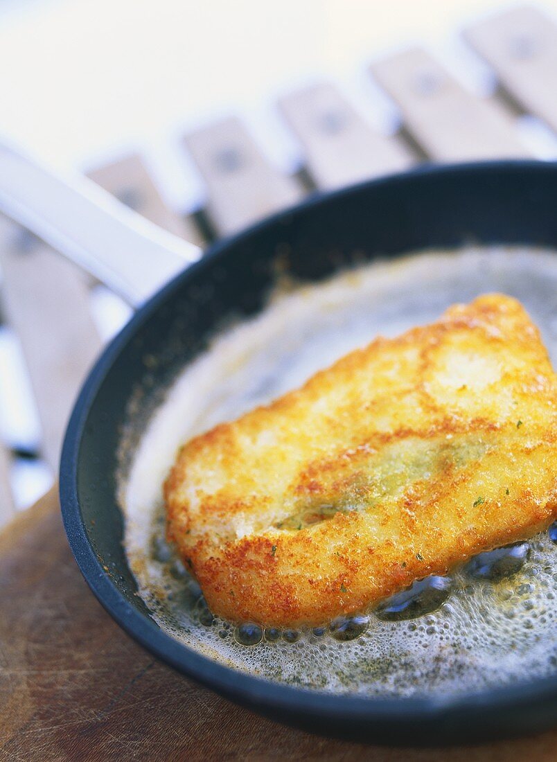 Frying breaded cod in frying pan