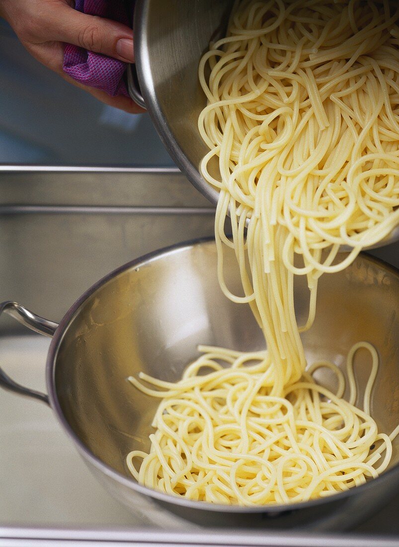 Gekochte Spaghetti in ein Sieb geben