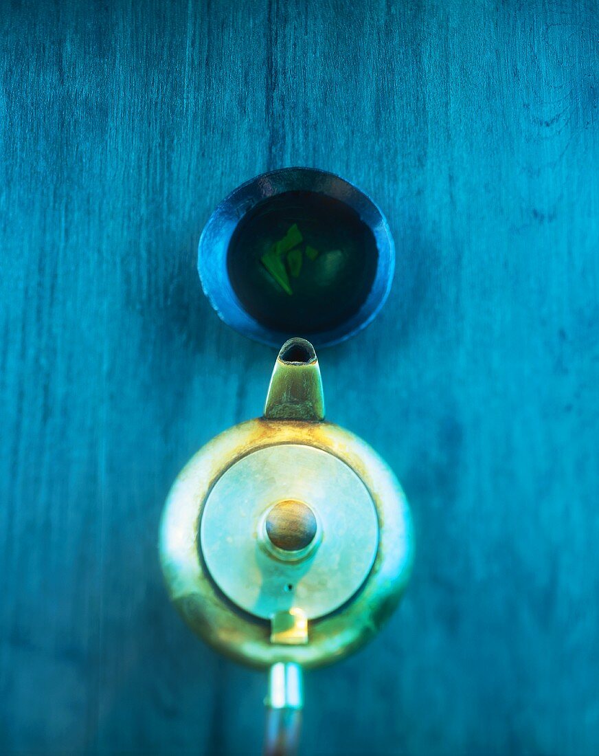 Teapot and tea bowl on blue wooden background