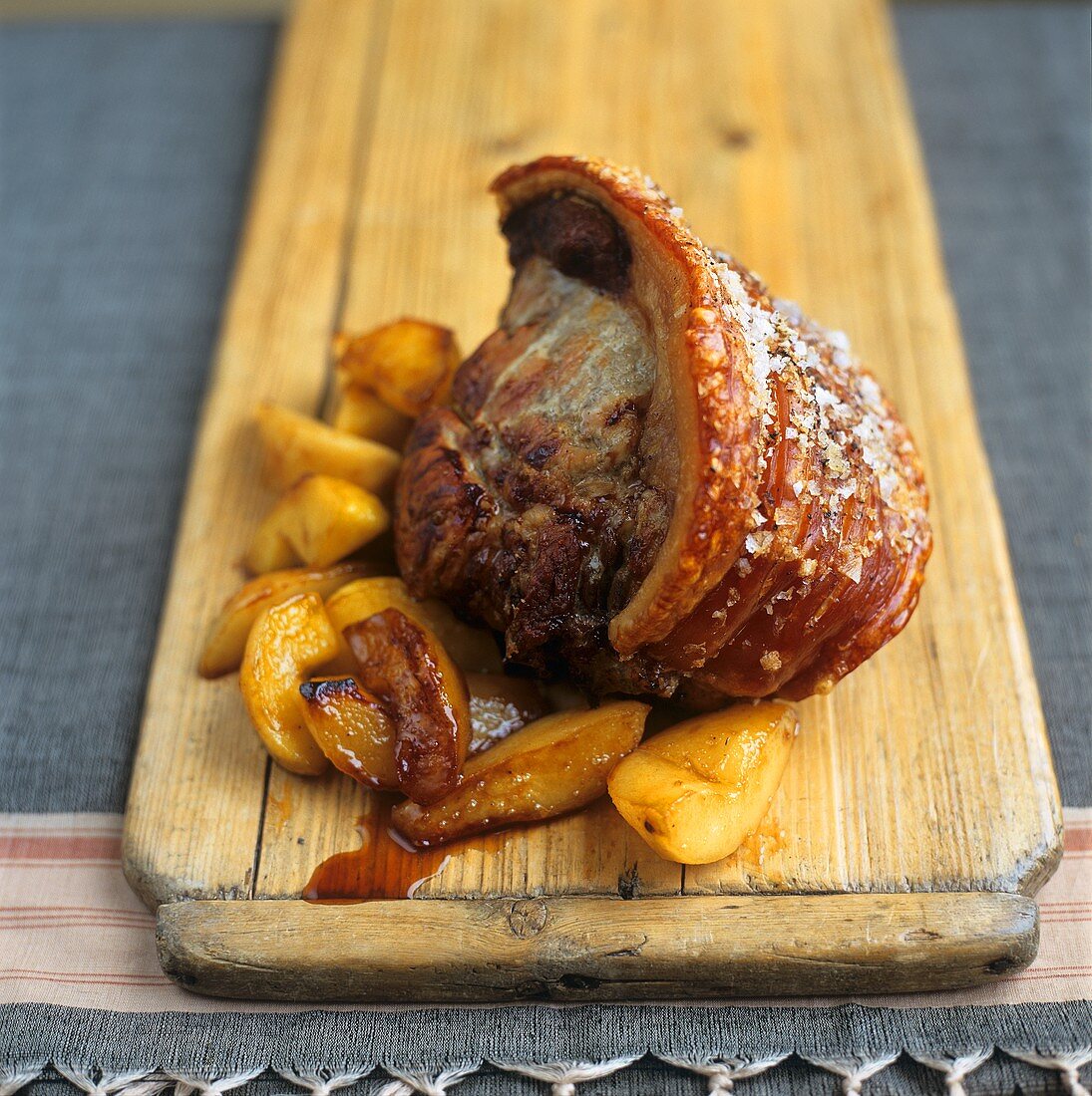 Roast pork with crackling, with potatoes on wooden board