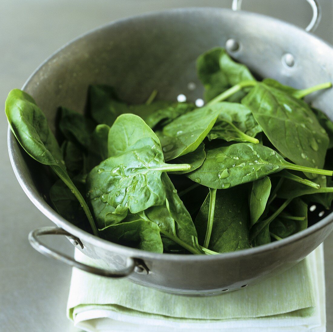 Fresh spinach leaves in a colander