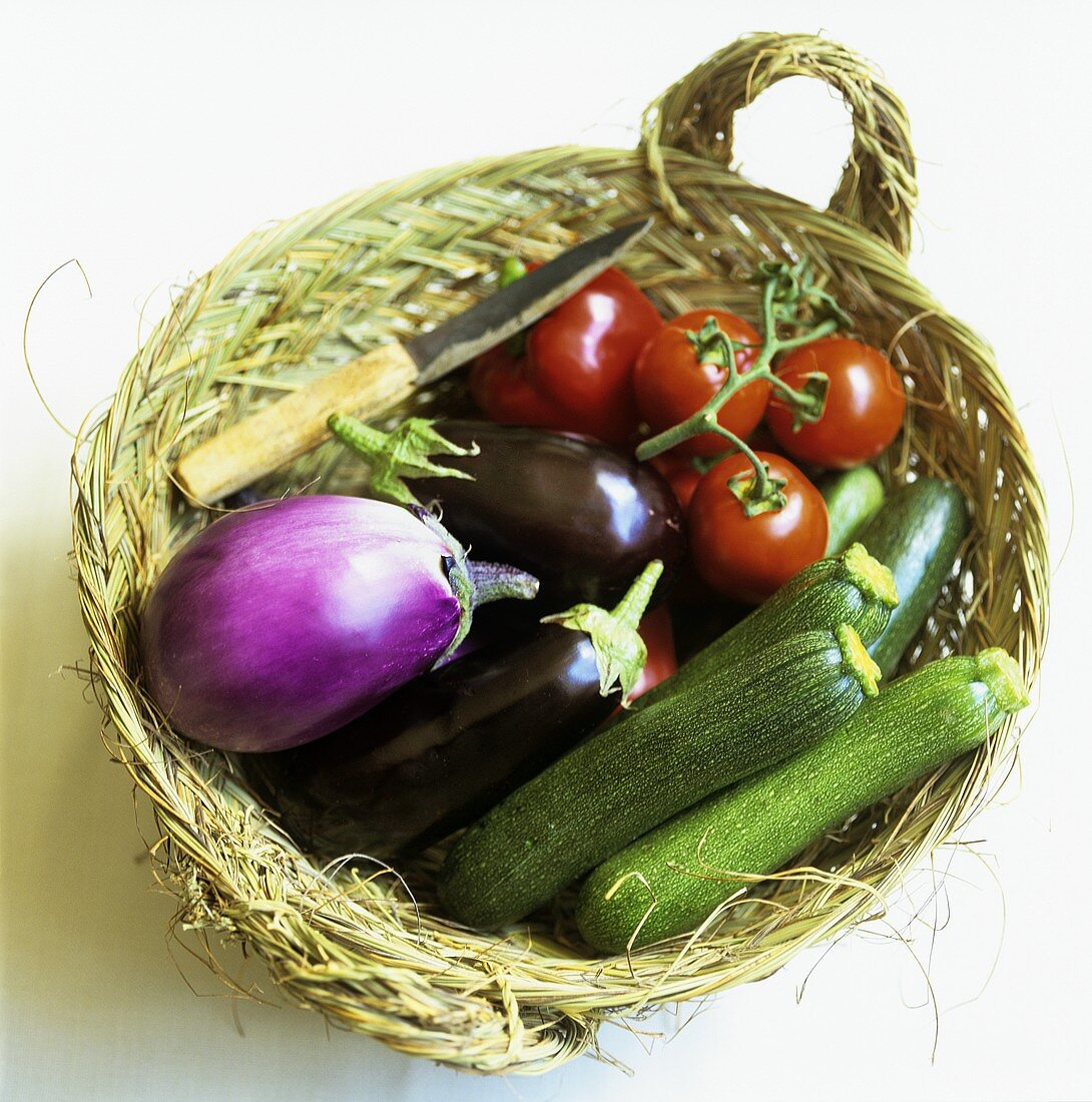 Korb mit Zucchini, Auberginen und Tomaten