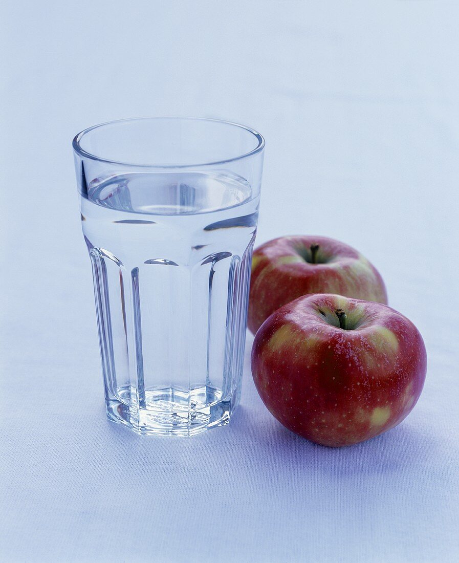 A glass of water and two apples