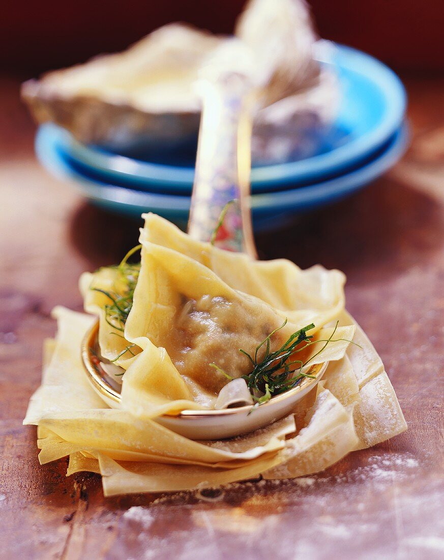 Curried fennel soup with oyster won ton on spoon