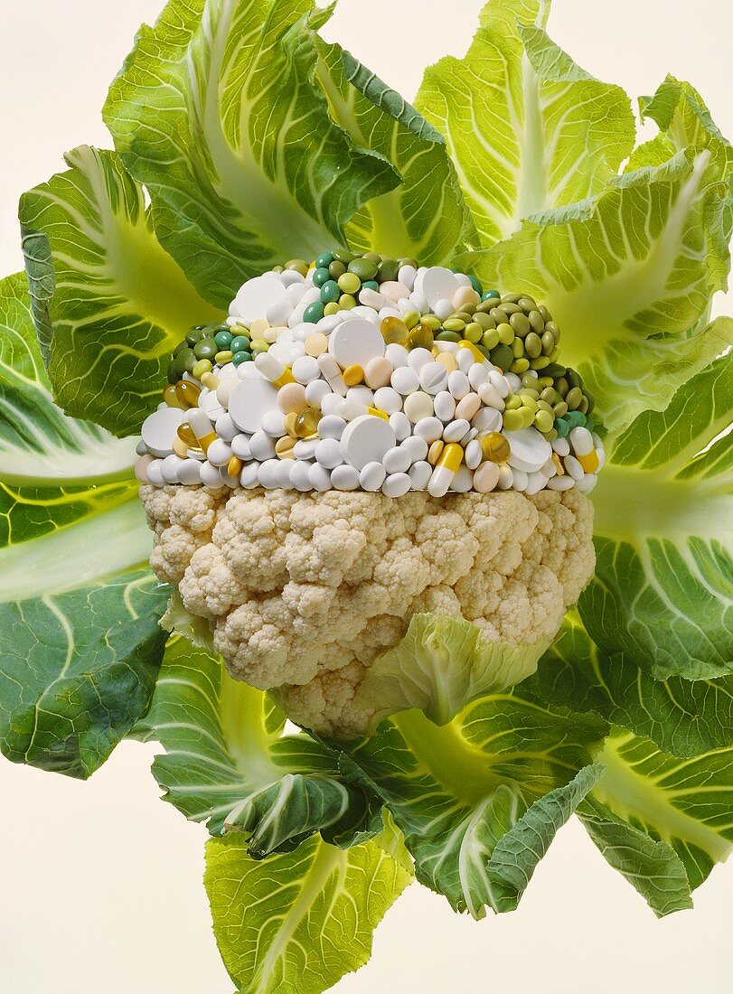 Natural and synthetic vitamins: cauliflower and tablets