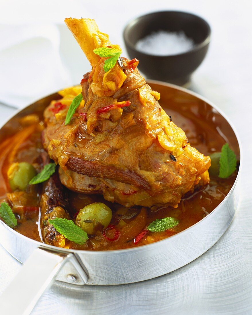 Braised lamb shank with mint in a frying pan (India)