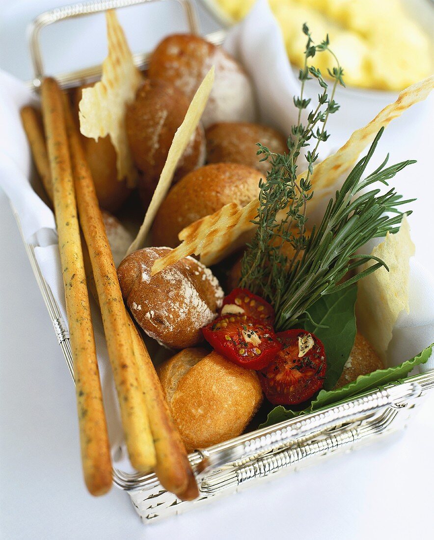 Basket of bread rolls and herbs