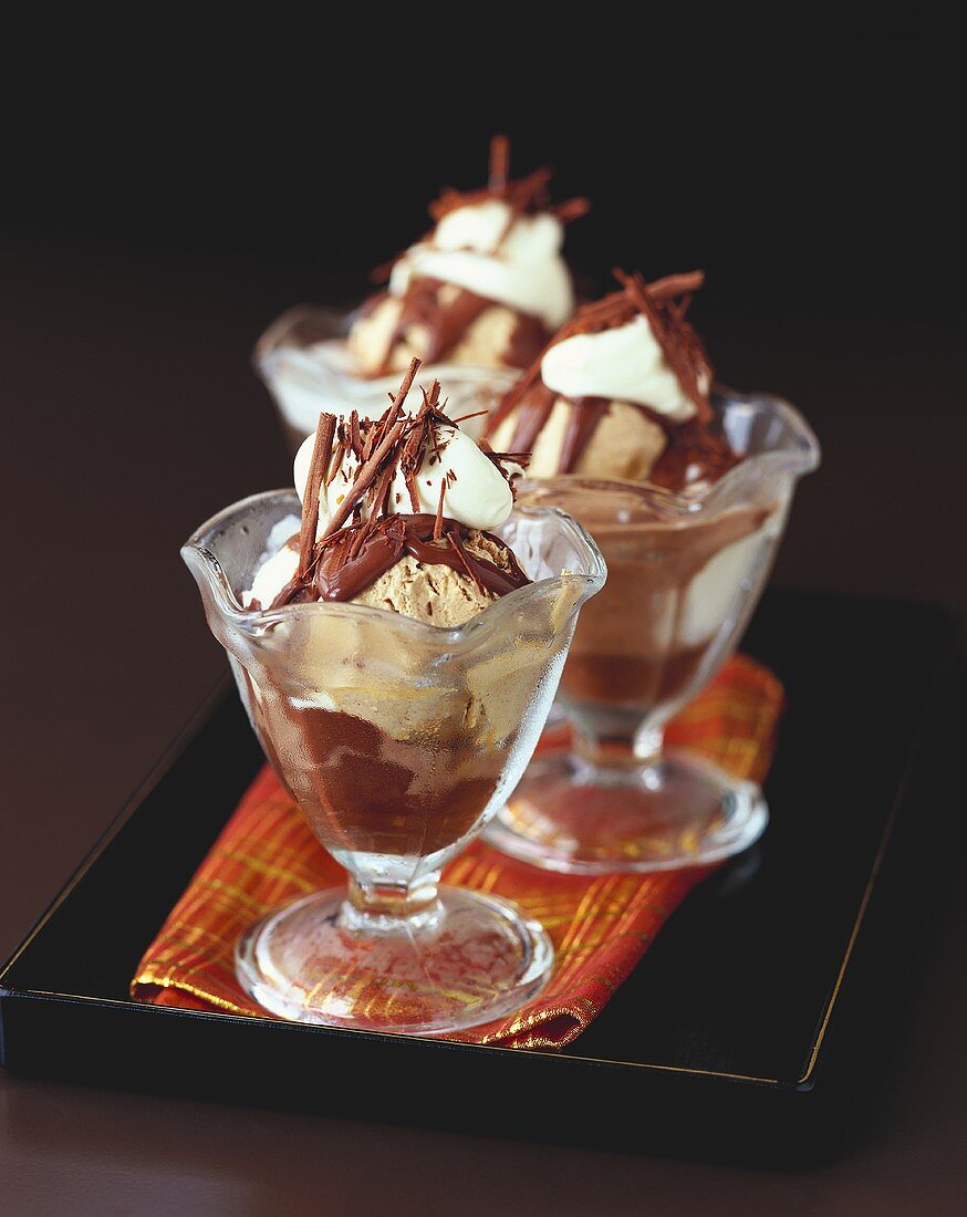Mocha ice cream and chocolate sauce in three sundae glasses