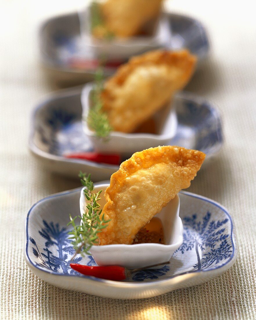 Three deep-fried won tons with potato filling in chili dip