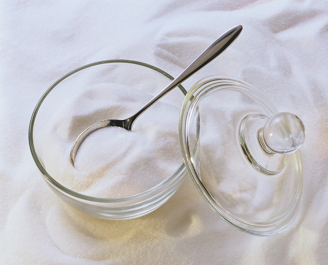 Zucker in einer gläsernen Zuckerdose und daneben