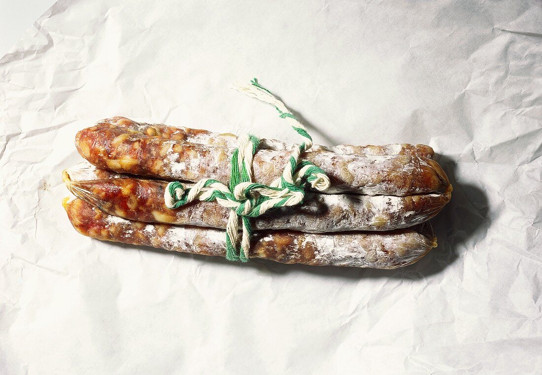 Three salami tied together on paper