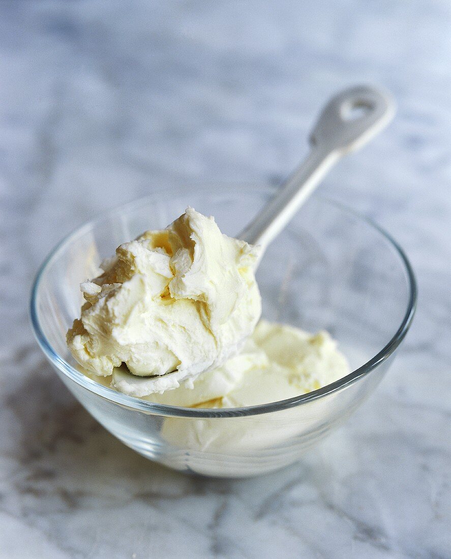 Mascarpone with spoon in a glass bowl