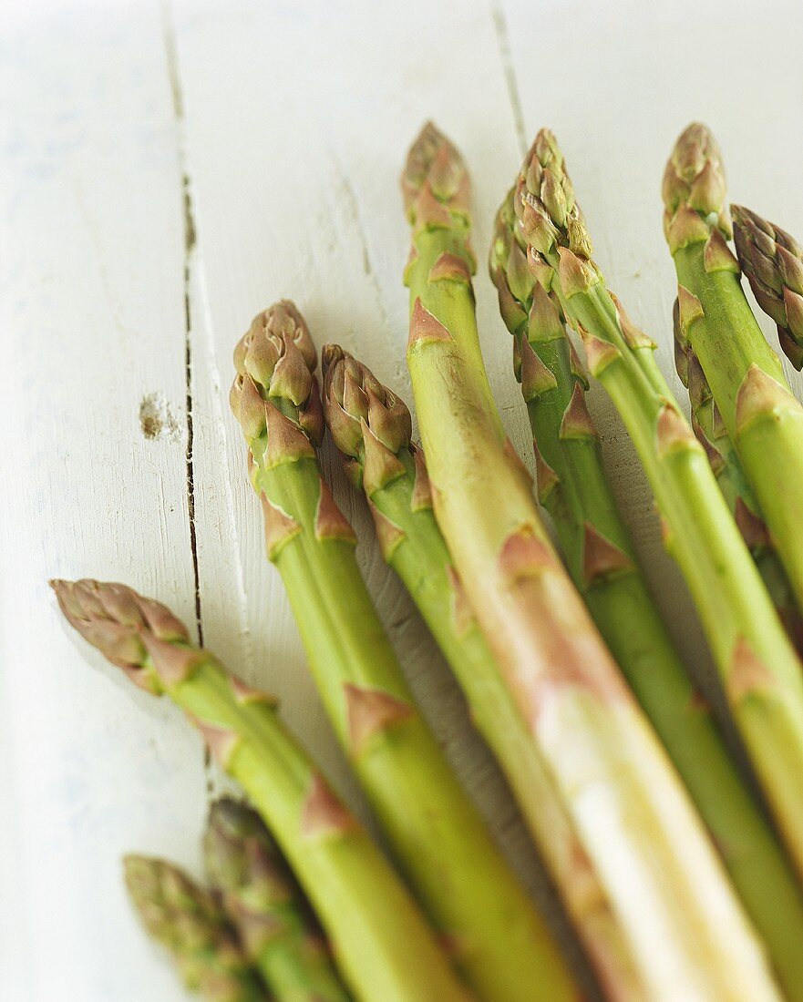 Grüner Spargel auf weiss gestrichenem Holzuntergrund