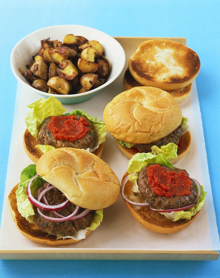 Four hamburgers and fried potatoes