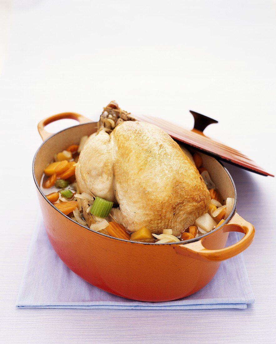 Poached chicken with vegetables in stew-pot