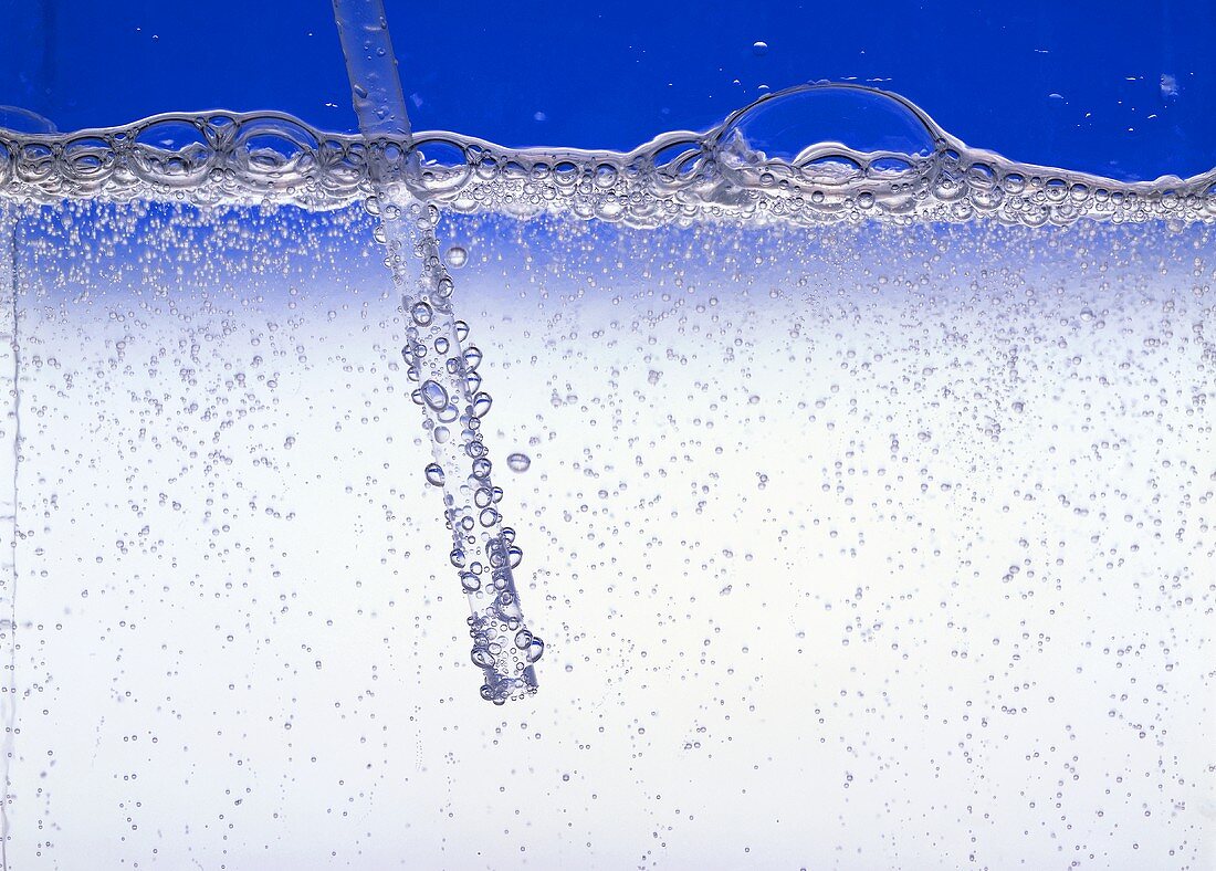 Sprudelndes Mineralwasser mit Strohhalm (Detail)