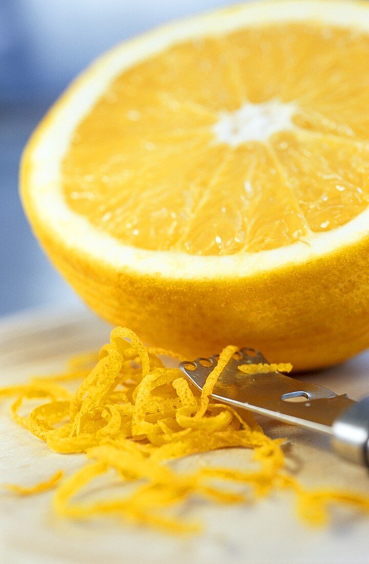Halbe Orange und Orangenzesten