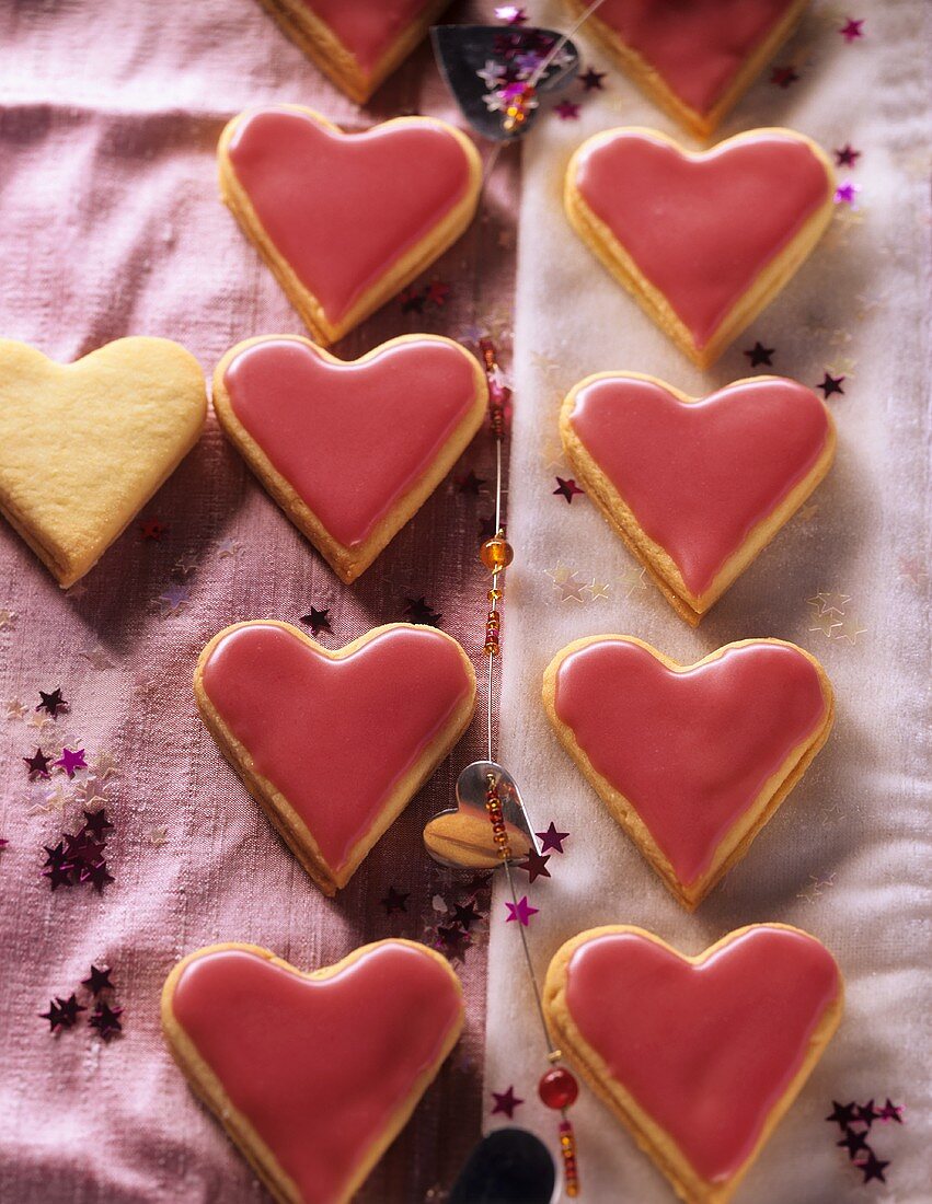 Heart-shaped biscuits with mango jam and glacé icing