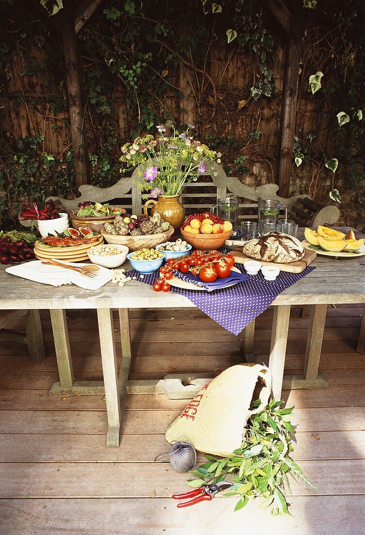 Gedeckter Gartentisch mit Gemüse und Früchten