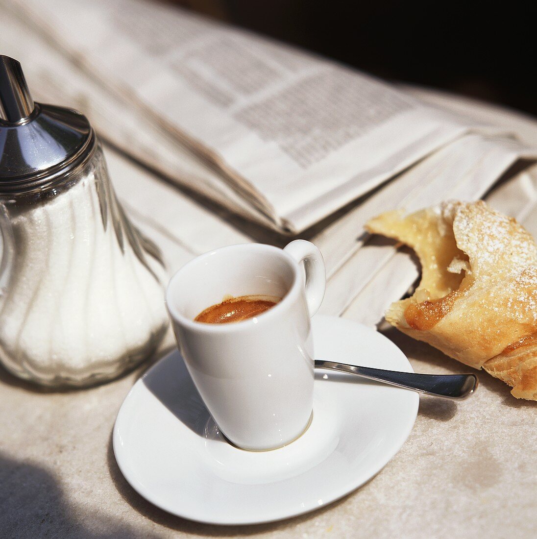 Espresso mit Gebäck und Zeitung