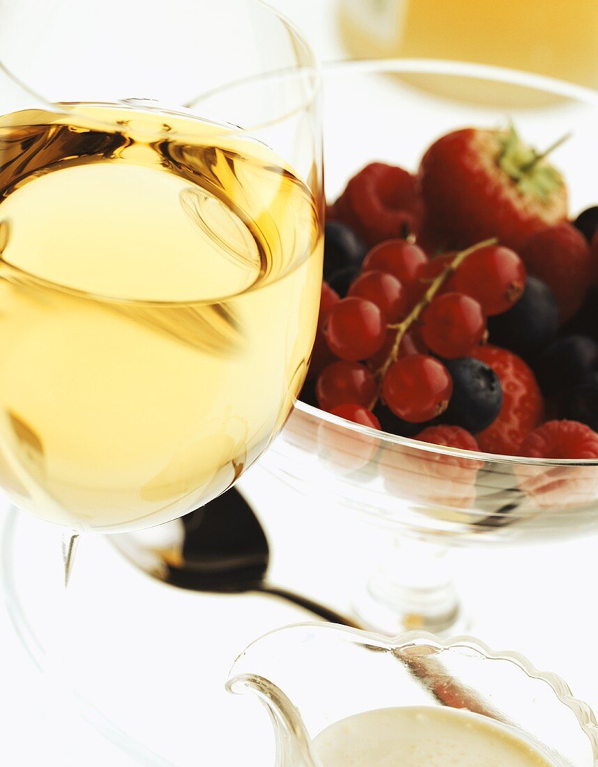 Weißwein und Schale mit frischen Beeren