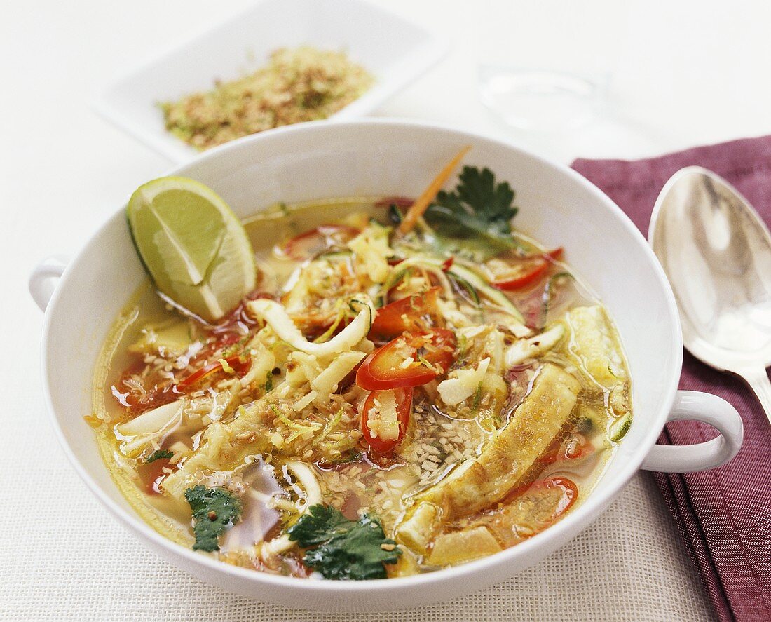 Thai soup with omelette strips and toasted coconut