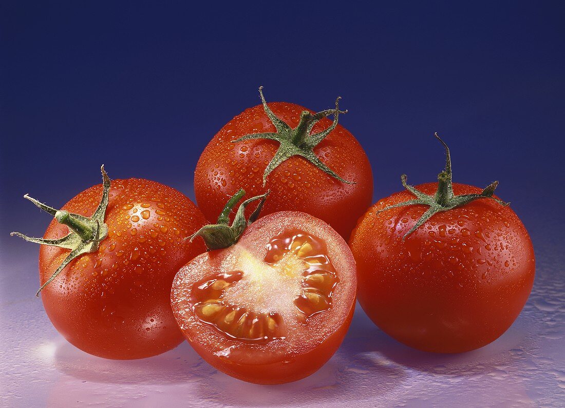 Drei ganze Tomaten und eine Tomatenhälfte