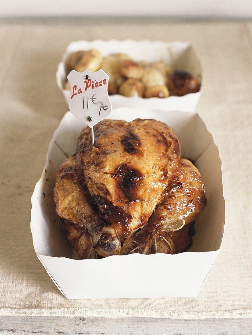 Roast chicken with price label in cardboard box