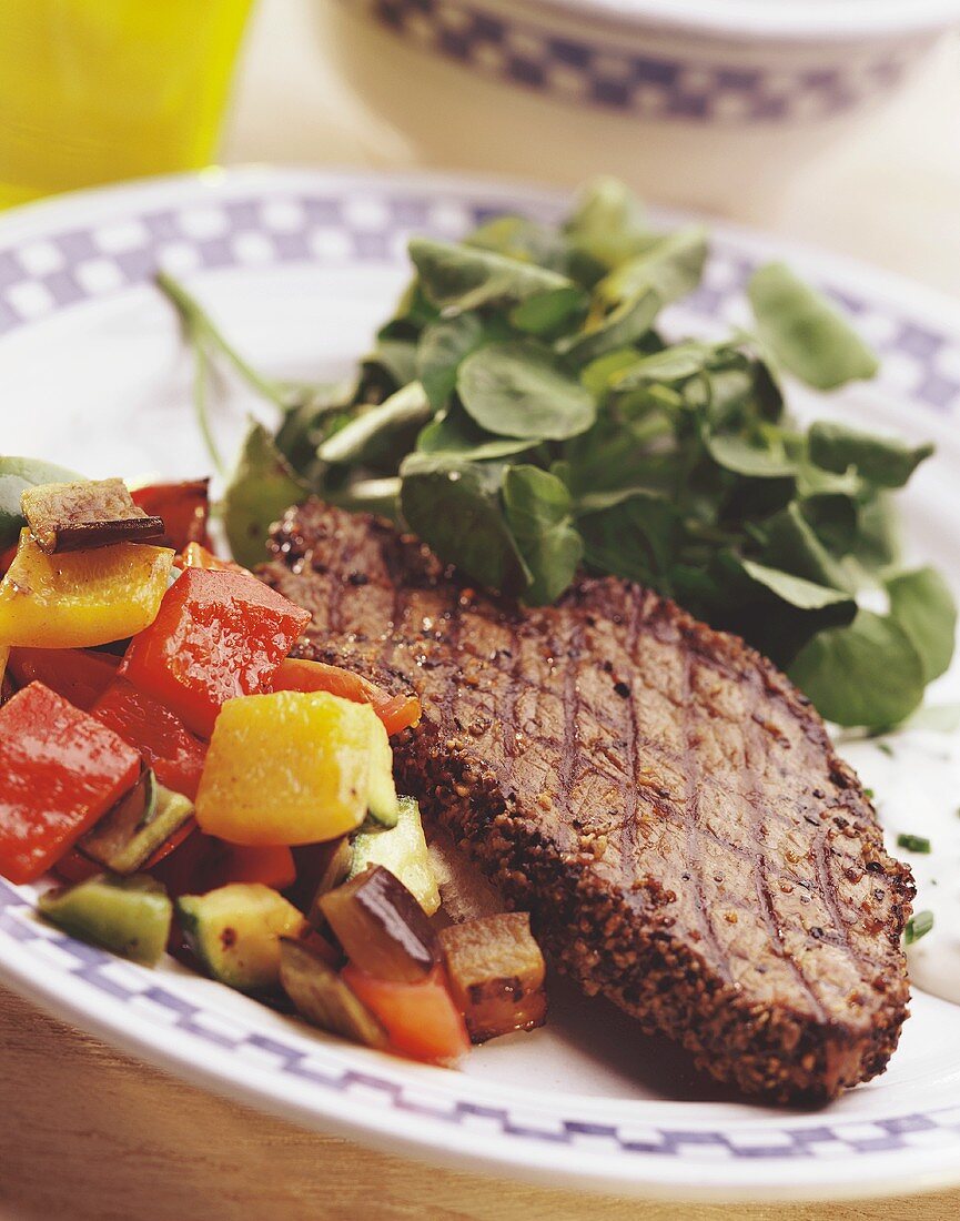 Grilled peppered steak with watercress and vegetables