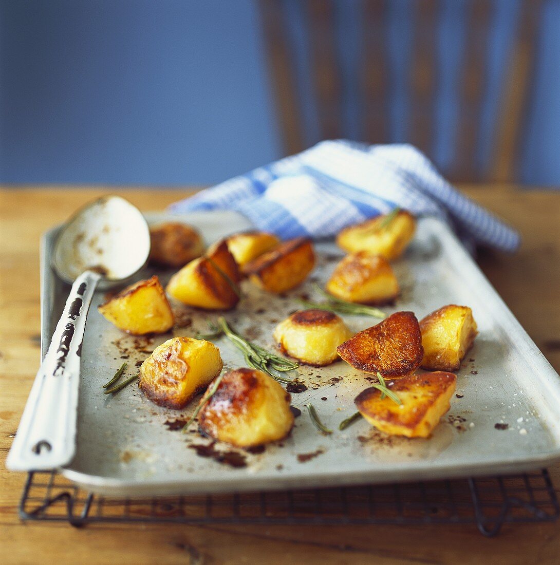 Roasted potatoes with rosemary on a baking tray