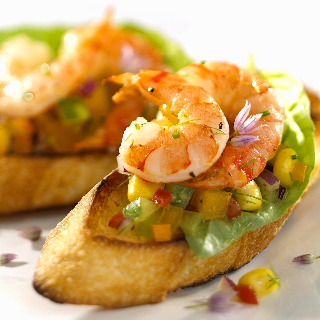 Crostini topped with shrimps and diced vegetables