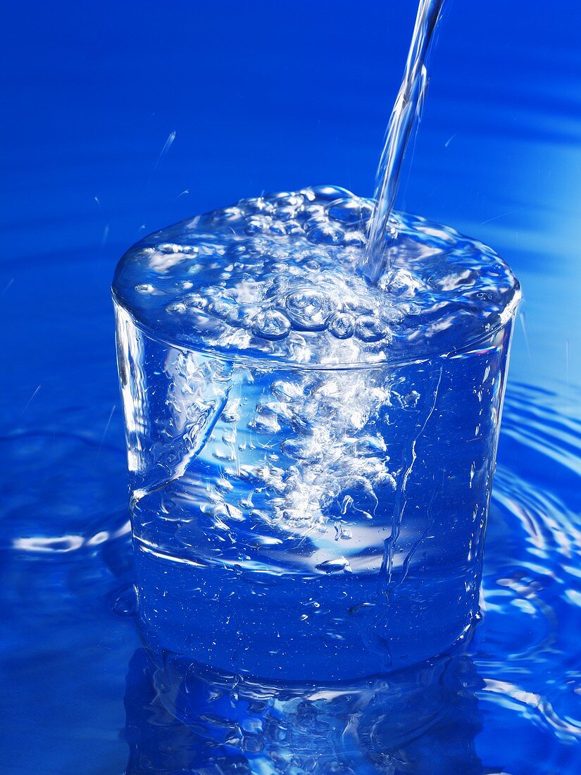 Wasser wird in ein Glas geschenkt