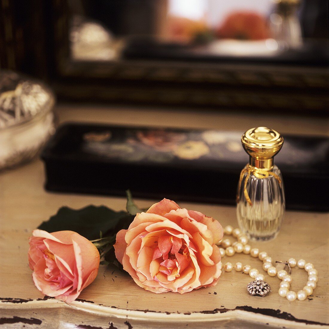 Rosen, Perlenkette und Parfüm