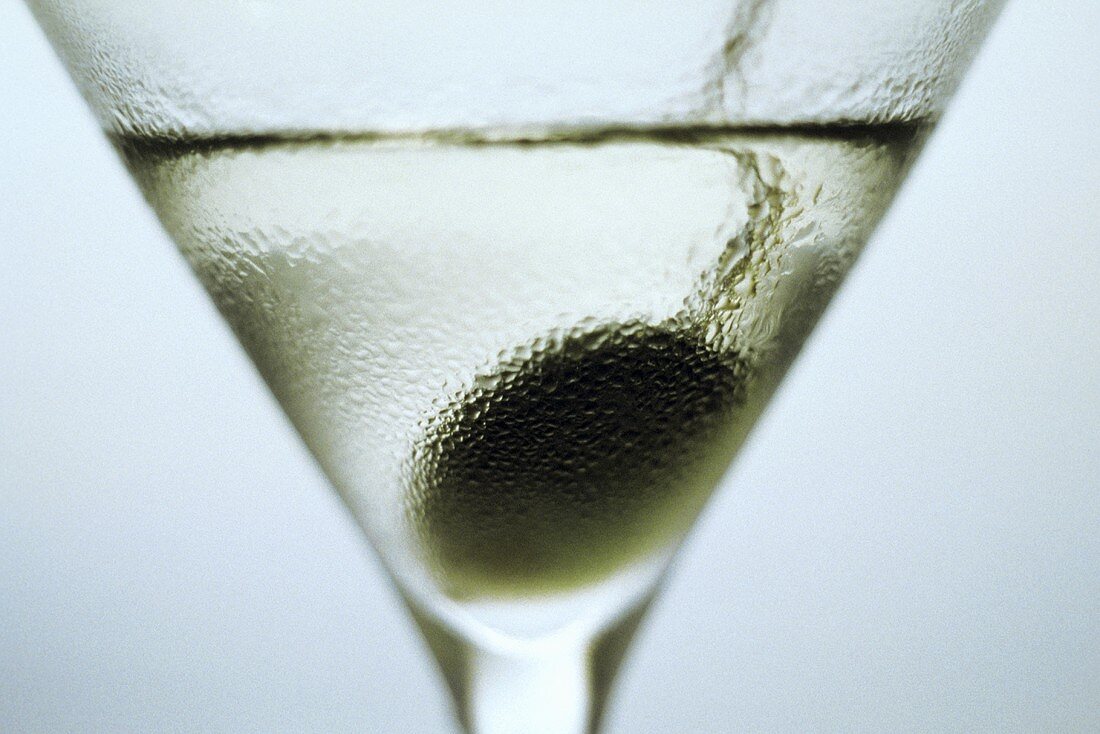 A glass of Martini with olive