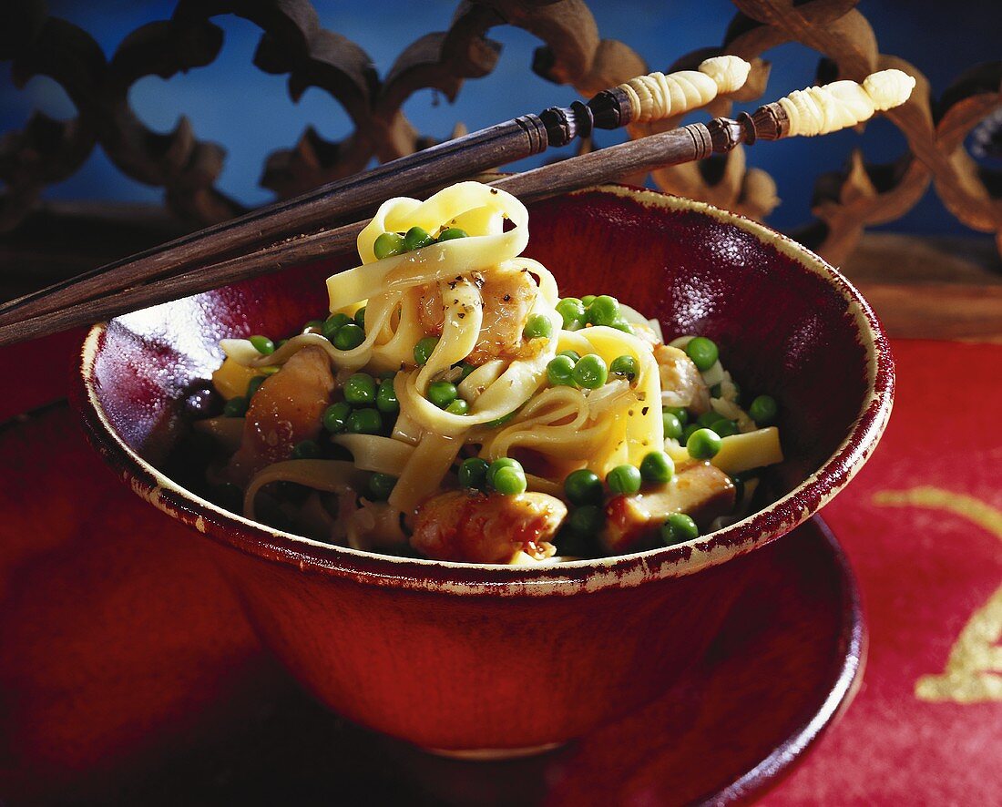 Noodles with chicken and peas, cooked in wok