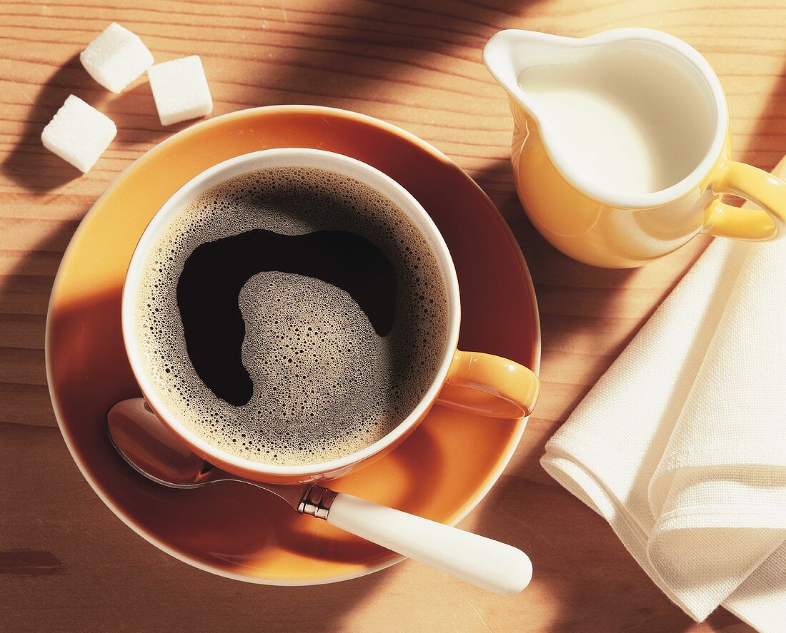 Eine Tasse Kaffee und ein Kännchen Kaffeesahne