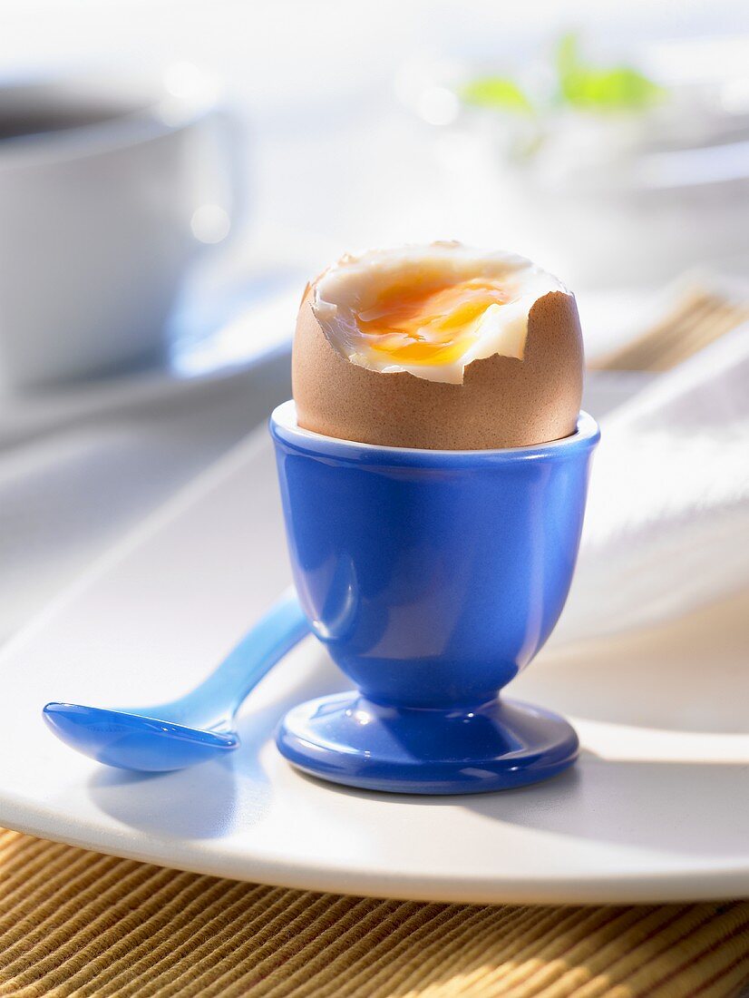 Weichgekochtes Frühstücksei in einem blauen Eierbecher