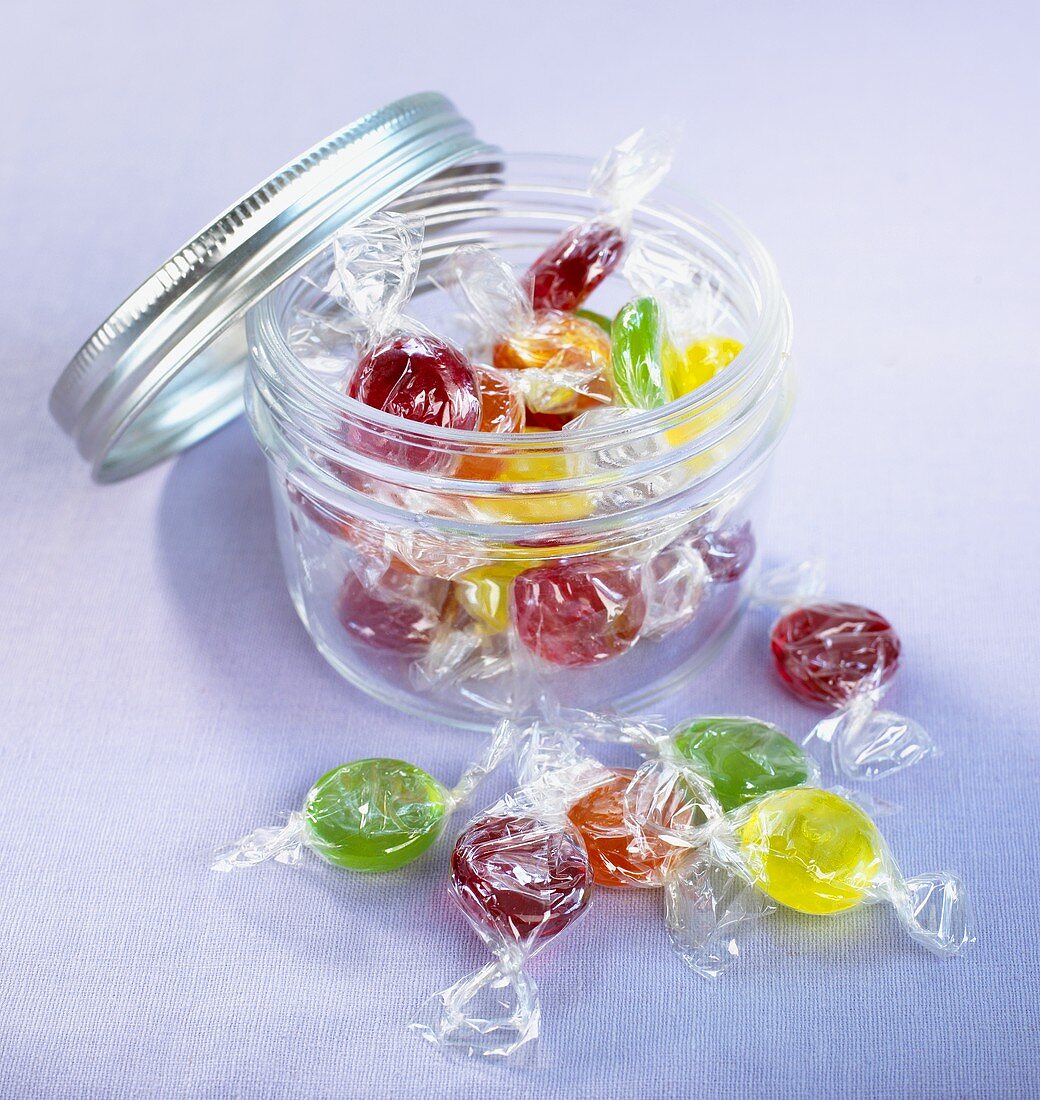 Assorted sweets in and in front of screw-top jar