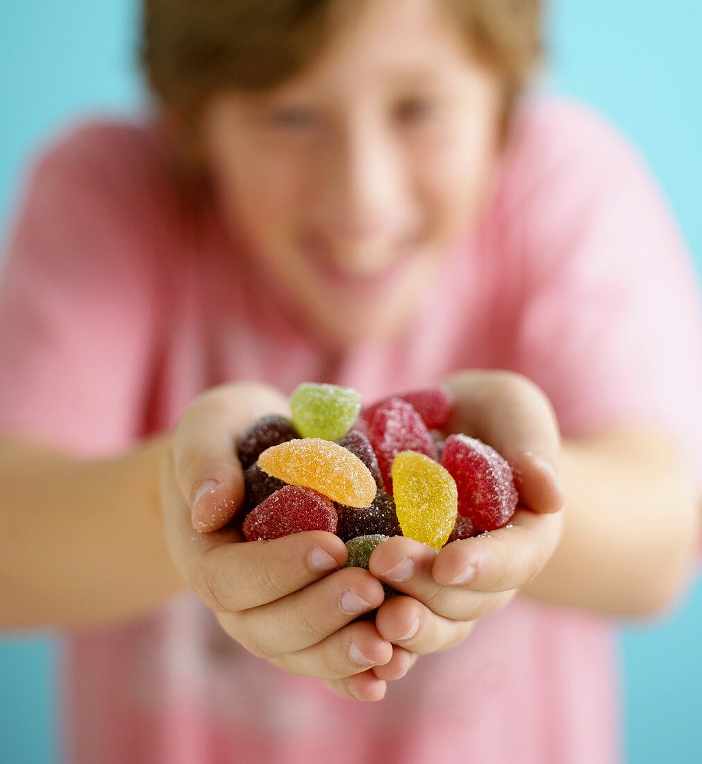 Assorted fruit jelly sweets, in a teenager's hands