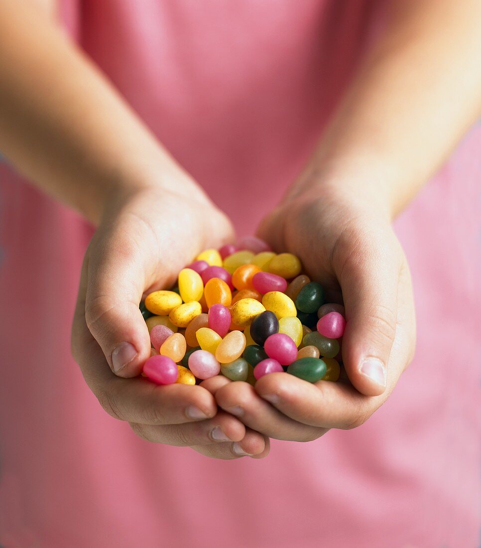 Assorted jelly beans, in a child's hands