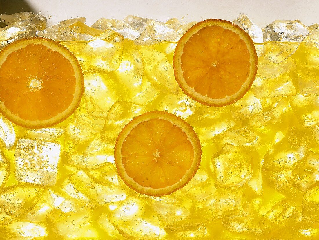 Orange juice with ice cubes and slices of orange