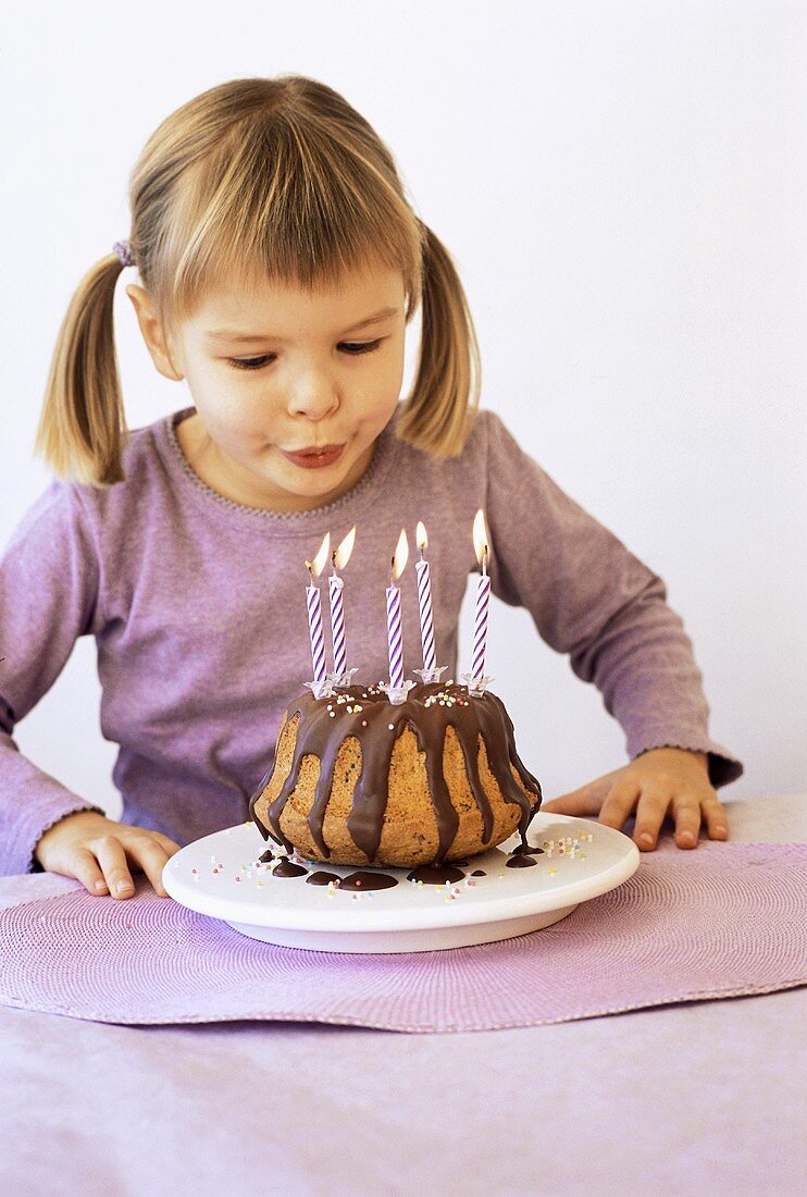 Girl blowing out candles on birthday cake