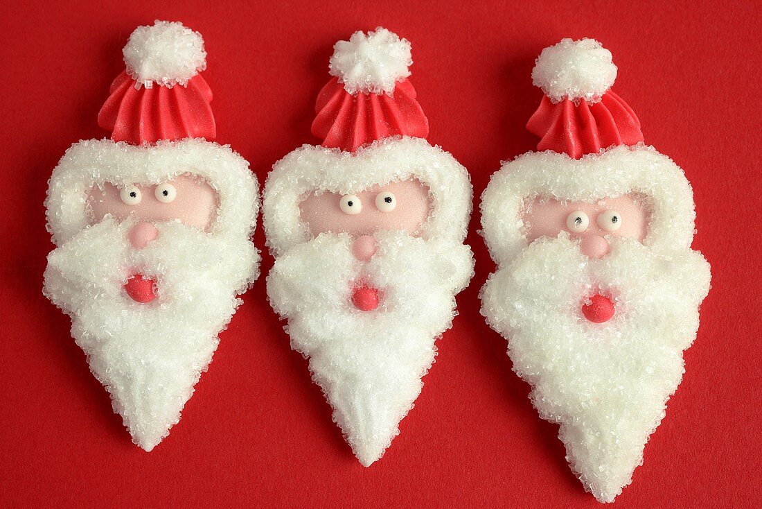 Three Father Christmas heads in icing