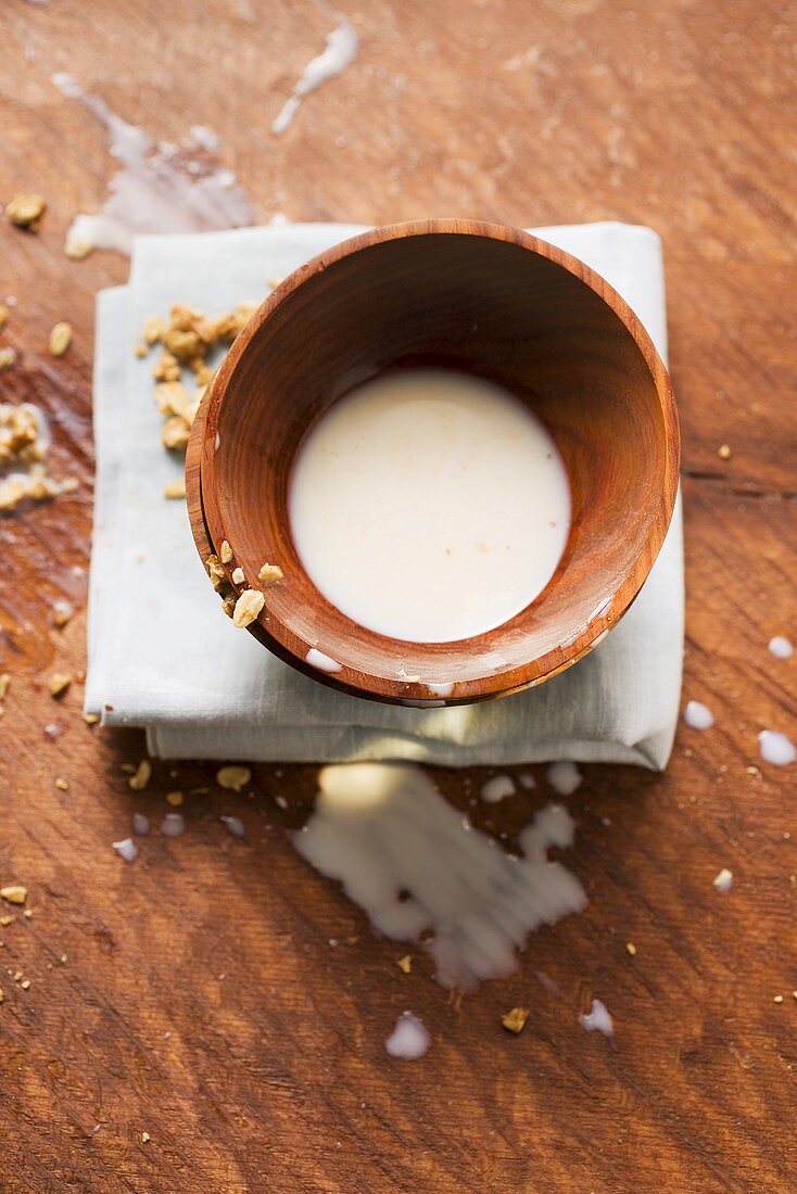 Cereal bowl with small amount of milk and spilt milk