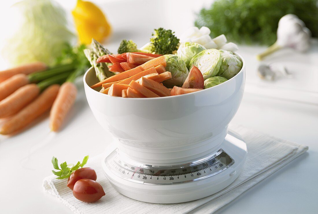 Freshly chopped vegetables on kitchen scales