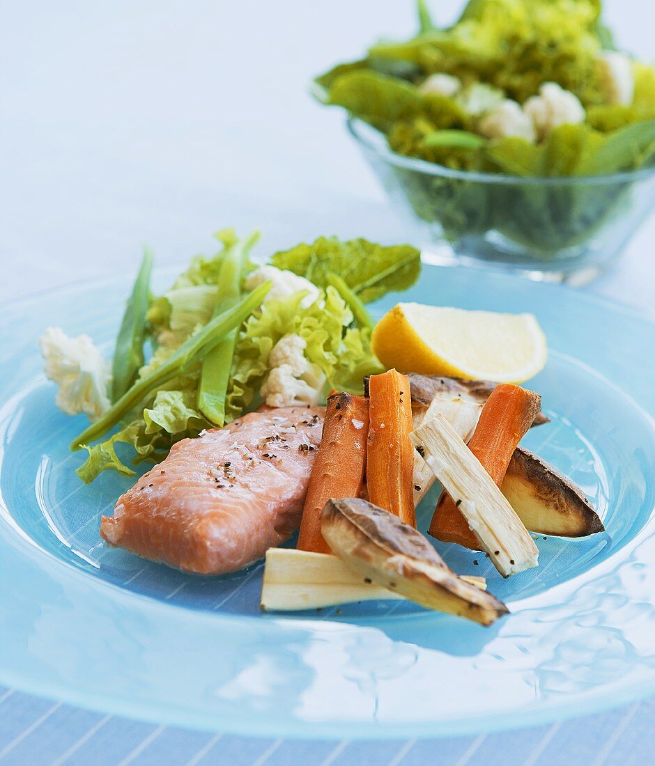 Oven-baked salmon fillet and vegetables with salad