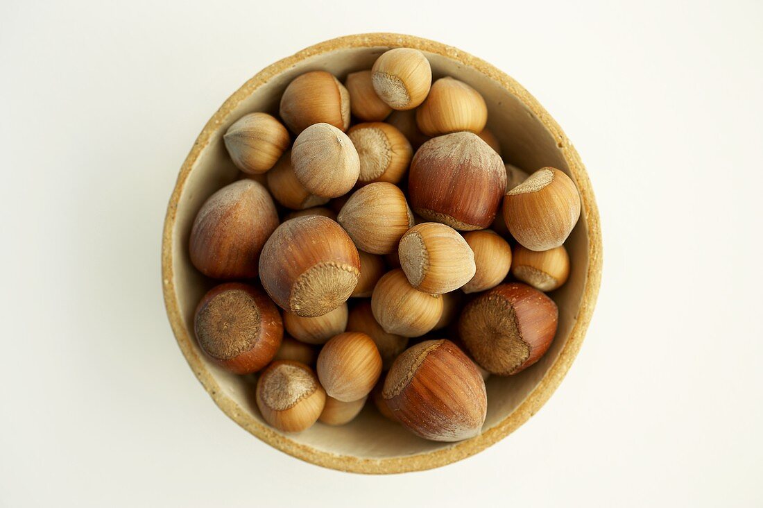 Two different types of hazelnuts in a bowl