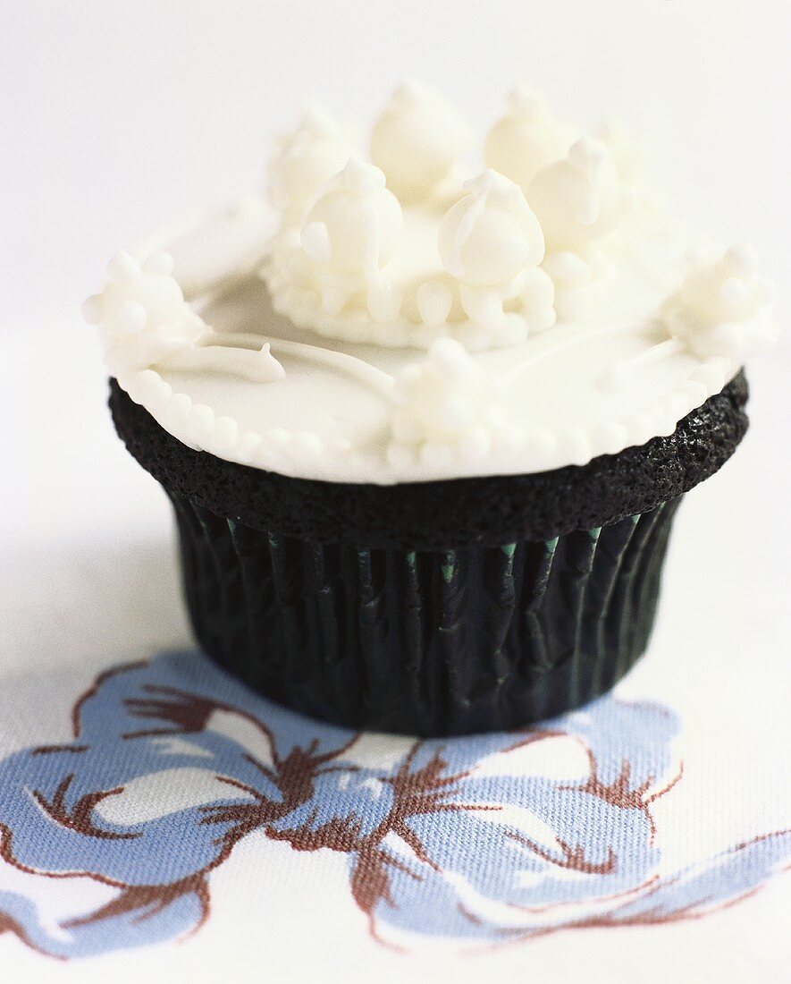 Chocolate cup-cake with white decoration